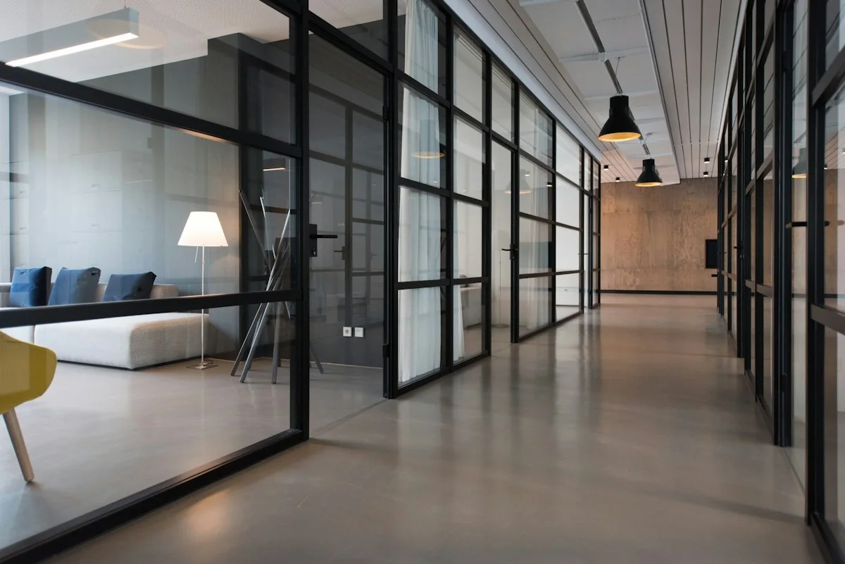 Illustrative office corridor with glass meeting-room partitions; not an available unit
